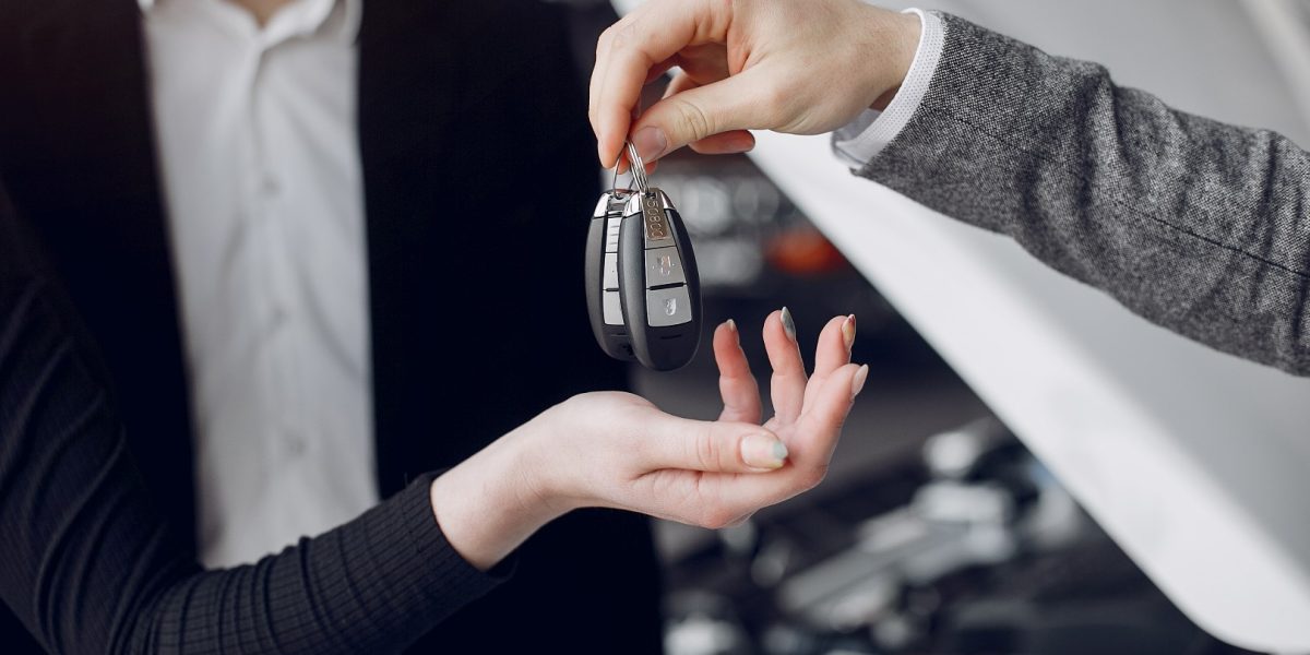 Couple in a car salon. Family buying the car. Elegant woman with her husband. Assistant with a clients