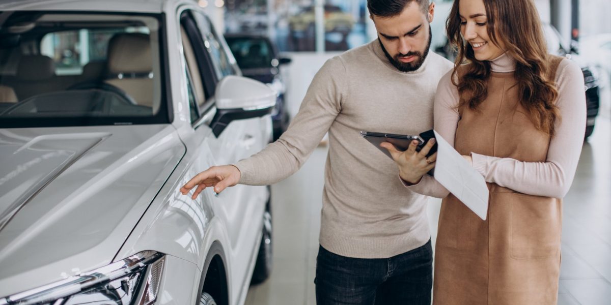 Saleswoman talking to customer in a car salon