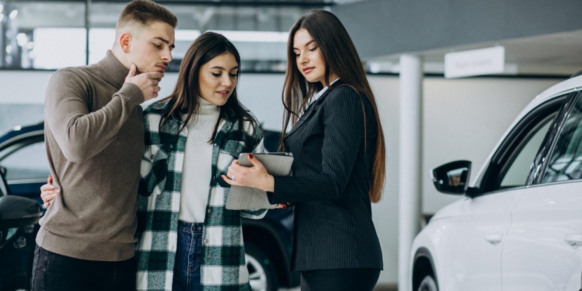 Young couple choosing a car in a car show room