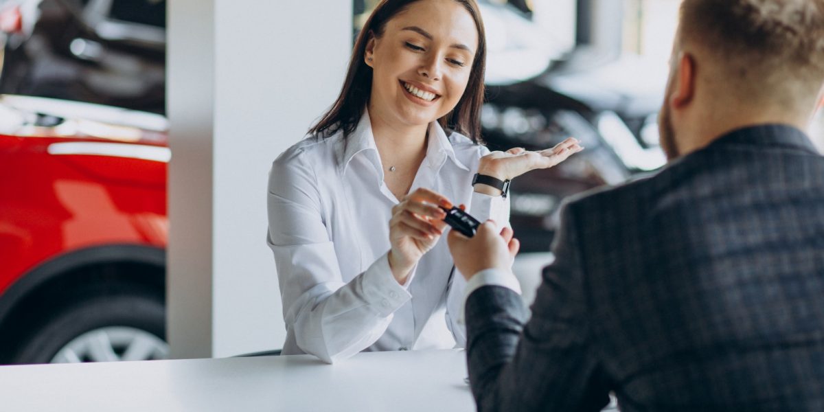 Man with sales woman in car showroom