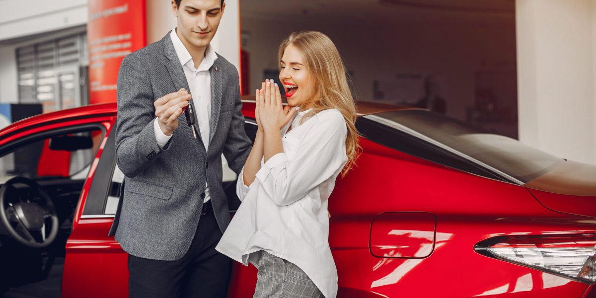 Couple buying the car. Pair in a car salon. Husband with vife choose the automobile
